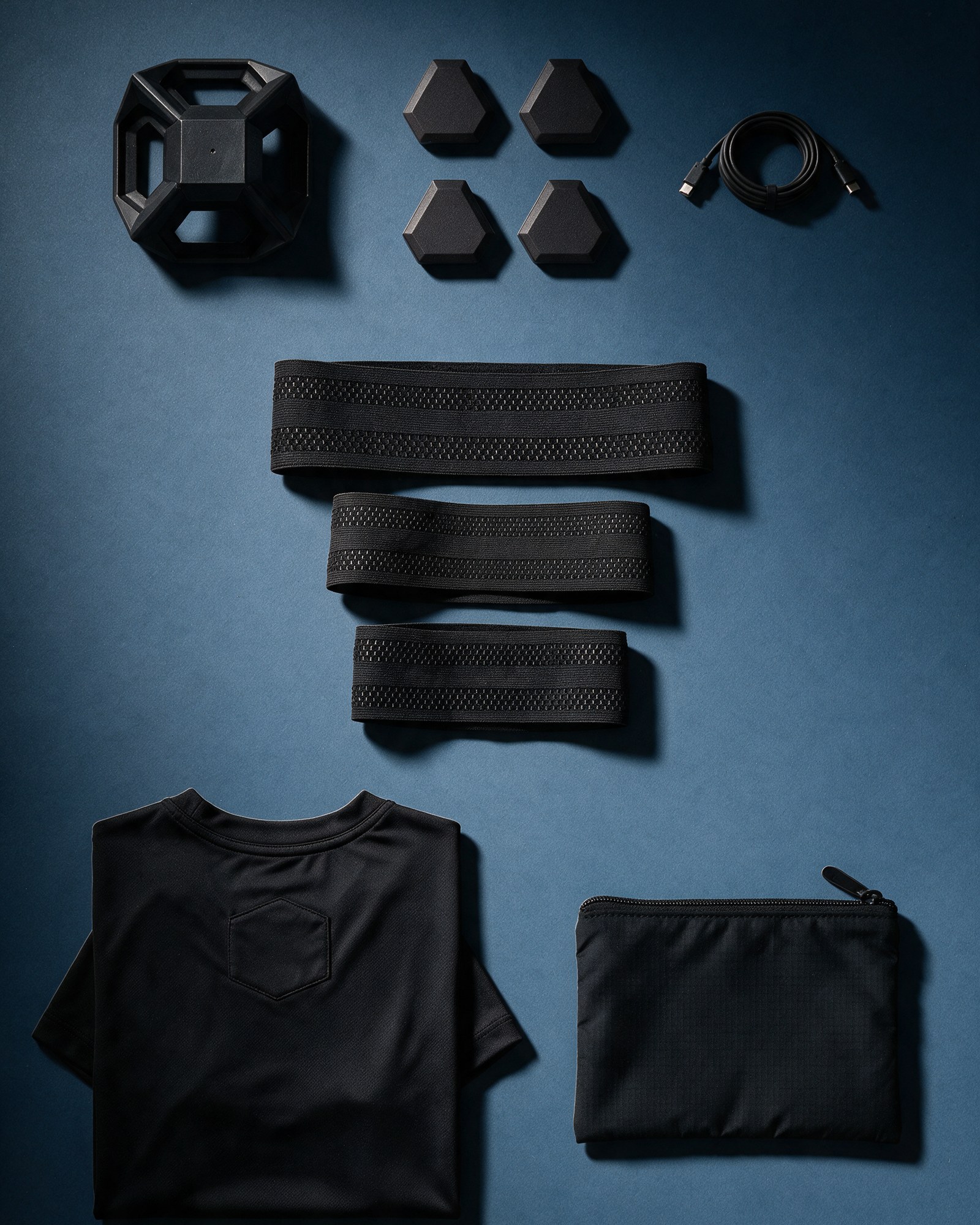 Everything in the Kit laid out: charging station, 4 sensors, straps, t-shirt, pouch and cable